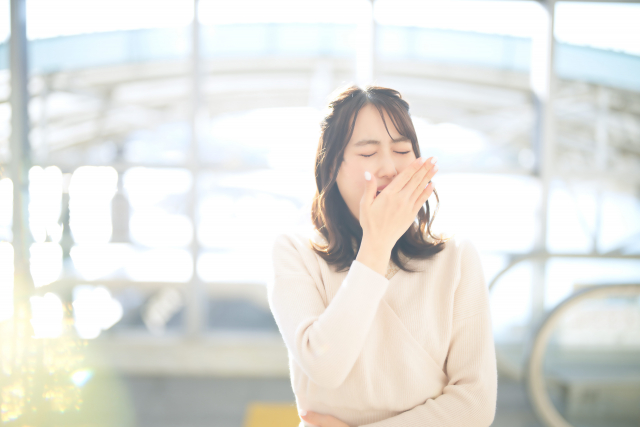 あくびをしてる寝不足の女性